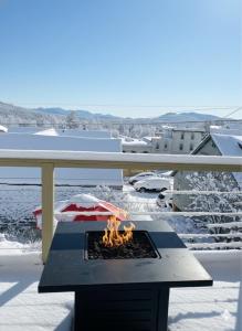 un braciere su un balcone con la neve per terra di Central Lake Placid Mountain Views a Lake Placid