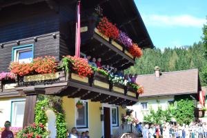 people on a balcony of a building with flowers at Pension Haus Rohrmoser in Annaberg im Lammertal +175 photos