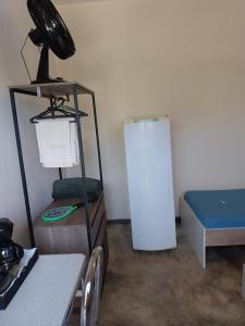 Kitnet - quarto - privativo في إتوبيفا: غرفة بسرير وثلاجة بيضاء