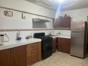 a kitchen with a stove and a refrigerator at Cozy and family - house Fundidora & Cintermex in Monterrey