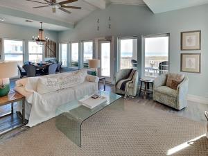 un soggiorno con un divano, un tavolo e delle sedie di Salty Kisses a Padre Island