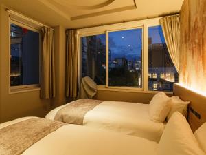 a bedroom with two beds and a window at Hotel Espasion Pontocho in Kyoto