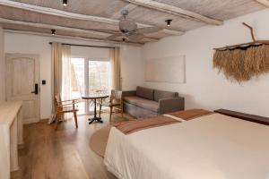 a bedroom with a bed and a couch and a table at Casa Solcor Boutique Bed & Breakfast in San Pedro de Atacama +169 photos