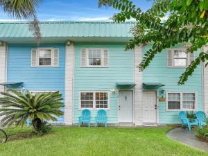 ein blaues Haus mit blauen Stühlen im Vorgarten in der Unterkunft Sea Stallion in Tybee Island