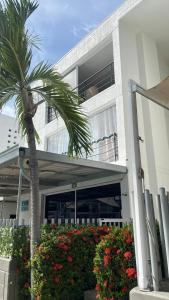 a palm tree in front of a building with flowers at Hermoso Apartasol en Santa Fe de Antioquia!!! in Santa Fe de Antioquia