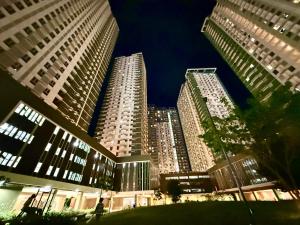 two tall buildings in a city at night at Cebu AvidaRiala Condotel by Go2Stays in Cebu City