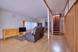 a living room with a chair and a television at APROStay富士河口湖小立17 in Fujikawaguchiko