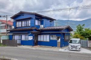 a blue house with a van parked in front of it at APROStay富士河口湖小立17 in Fujikawaguchiko
