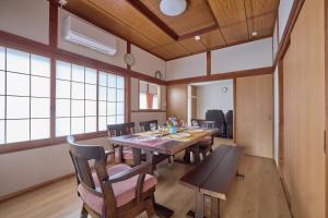 a dining room with a large wooden table and chairs at APROStay富士河口湖小立17 in Fujikawaguchiko
