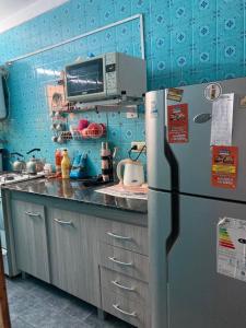 eine Küche mit Kühlschrank und Mikrowelle in der Unterkunft Los Dos Pinos in Villa Gesell