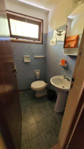 ein Badezimmer mit Toilette und Waschbecken in der Unterkunft Los Dos Pinos in Villa Gesell