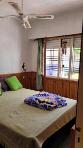 ein großes Bett in einem Zimmer mit Fenstern in der Unterkunft Los Dos Pinos in Villa Gesell