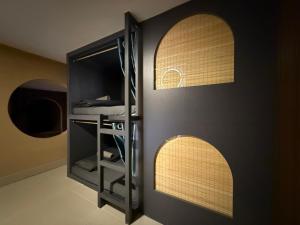 een kamer met een zwarte muur met twee boogramen bij Mobylette Sai Gon in Ho Chi Minh-stad