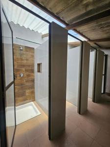 een badkamer met een douche met een glazen deur bij Old House Hostel in Sucre
