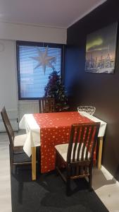 a dining room table with a christmas tree in the window at Cozy economy room for 2 persons at the shopping area in Rovaniemi +4 photos