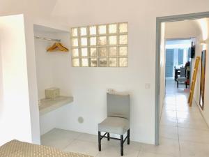 a white room with a chair and a window at Lupi's Cave House in Fira