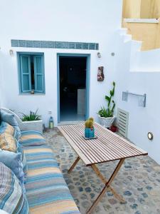 a living room with a table and a couch at Lupi's Cave House in Fira