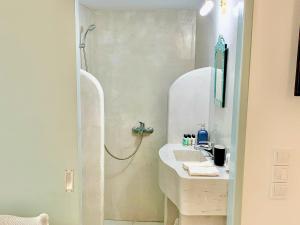 a bathroom with a sink and a shower at Lupi's Cave House in Fira