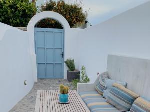 a patio with a couch in front of a door at Lupi's Cave House in Fira