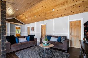 een woonkamer met twee banken en een tafel bij Rustic Lakefront Cottage with Fire Pit and Scenic Views in Brechin