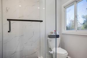 een witte badkamer met een toilet en een raam bij Rustic Lakefront Cottage with Fire Pit and Scenic Views in Brechin +28 foto's