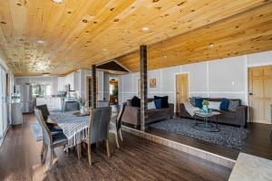 een eetkamer en een woonkamer met een houten plafond bij Rustic Lakefront Cottage with Fire Pit and Scenic Views in Brechin