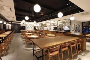 a restaurant with wooden tables and chairs and lights at HATAGO HIKONE - Main building in Hikone