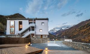 a house in the middle of a mountain at Siguniang Mountain Waiting for the Wind Snow Mountain Guesthouse in Mount Siguniang