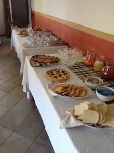 una fila de mesas con diferentes tipos de comida en ellas en Le Fontane, en Urbino