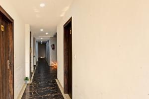un corridoio con pareti bianche e pavimento piastrellato nero di Super Collection O Mountain View Resort a Rānchī
