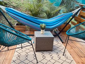 a hammock on a deck with two chairs and a table at L'isménia, Le Loft in Le Gosier
