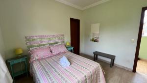 a bedroom with a bed with a pink bedspread at Pousada Cipó in Serra do Cipo +72 photos
