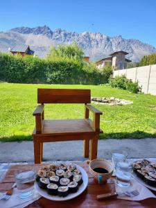 a table with a bench with a plate of food at Anlupa Casa in El Bolsón