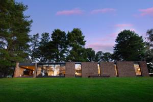 a brick building with windows on a grass field at Gabion Hill in Glenlyon