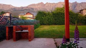 a bench in a yard with mountains in the background at Anlupa Casa in El Bolsón