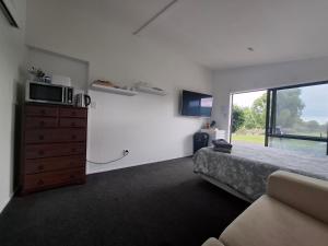 una camera con letto e comò con forno a microonde di Shambala a Te Kauwhata