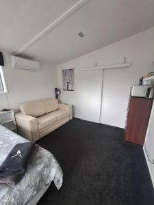 una camera da letto con un letto e un divano in una stanza di Shambala a Te Kauwhata