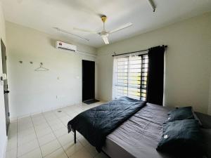 Un dormitorio con una cama y un ventilador de techo. en QQ UniStay, en Pagoh