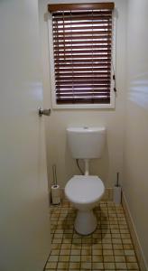Denman Stay - Worker Friendly & Great Value في Denman: حمام مع مرحاض مع نافذة وأرضية من البلاط +18 صورة