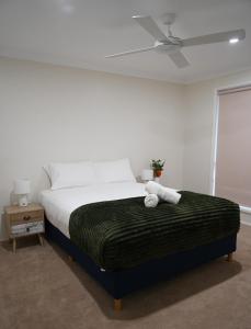 Denman Stay - Worker Friendly & Great Value في Denman: غرفة نوم بها سرير ومروحة سقف