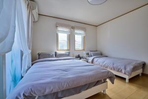 富士河口湖フルハウス的有两张床的房间有两扇窗户