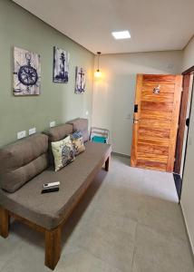 - un salon avec un canapé et une porte en bois dans l'établissement Casas Costa Dos Corais, à Japaratinga