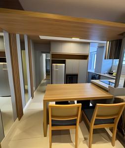 a kitchen with a wooden table and chairs at Seu apê de férias - Praia Grande in Praia Grande