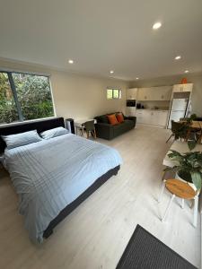 a bedroom with a bed and a living room at Whangapoua retreat in Whangapoua