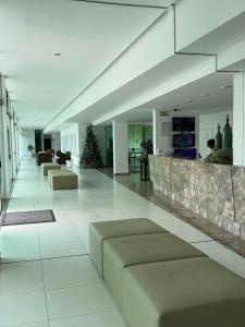 a lobby with couches and a christmas tree in a building at Luxor Tambau 211 by Viva Hospedagens in Tambaú