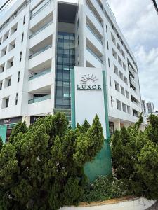 a large building with a sign in front of it at Luxor Tambau 211 by Viva Hospedagens in Tambaú