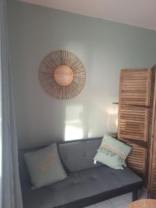 a living room with a gray couch and a mirror at Pause tropicale in Le Diamant