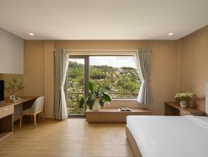 ein Schlafzimmer mit einem Bett und einem großen Fenster in der Unterkunft Gold View Boutique Hotel Đà Lạt in Da Lat