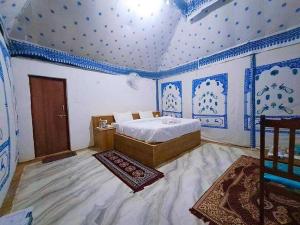 SPOT ON Dream Land Desert Camp في جيلسامر: غرفة نوم بسرير وجدران زرقاء وبيضاء
