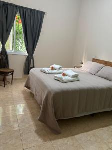 a bedroom with a bed with towels on it at El retamo - Casa Turística in San Rafael